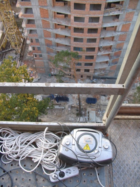 У люльці на 25 поверх. Страшно, але з музикою. Знизу - величезні сосни.